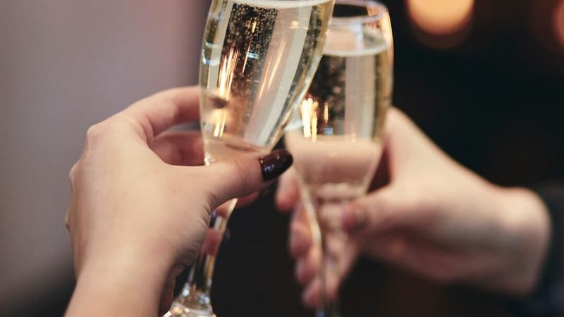 Clinking Drinks by the Fireplace